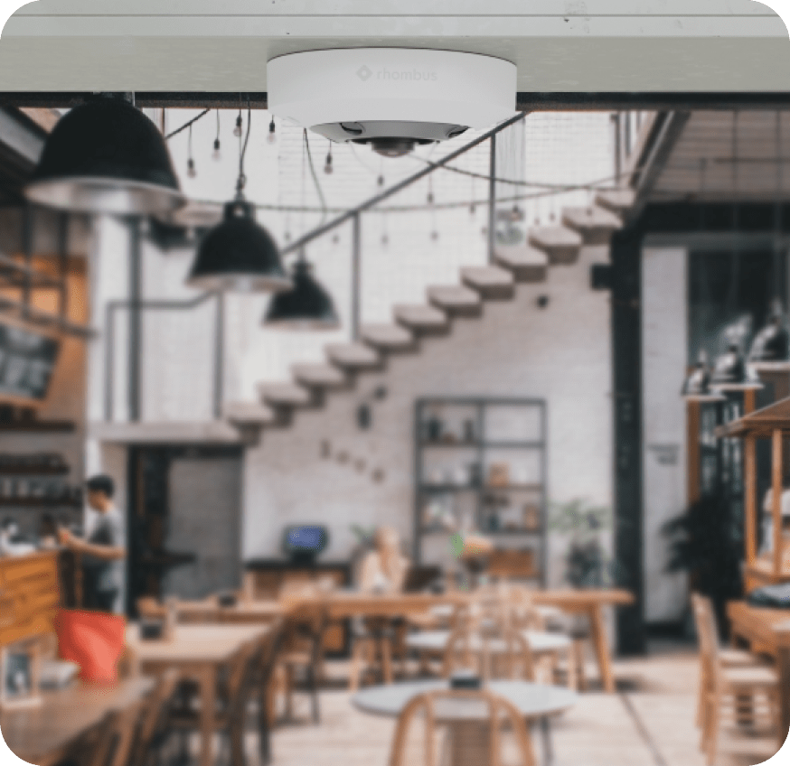 Rhombus fisheye camera with advanced features installed indoors at a workplace, eliminating the need for multiple progressive scan cameras.